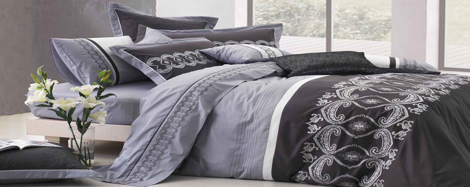 Embroidered grey and black bedding set in a bright bedroom